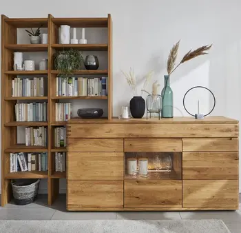 Sideboard aus Massivholz neben dem ein Bücherregal aus Massivholz steht.