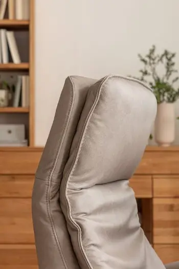 Nach vorne geknickte Kopflehne eines grauen Relaxsessels mit Lederbezug.