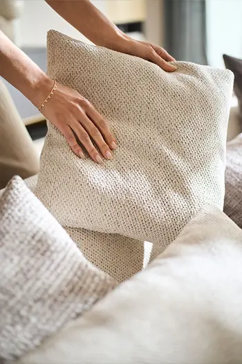 Kissen in passendem beigen Stoff zu hochwertigem Sofa.