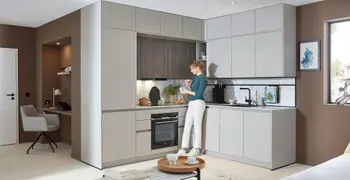 Frau in Kueche isst einen Muffin