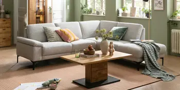 Helles Ecksofa im Wohnzimmer mit Couchtisch und Deko.