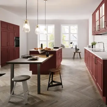 Still volle große Landhausküche in dunklem Rot und einer Kücheninsel in der Mitte.&nbsp;