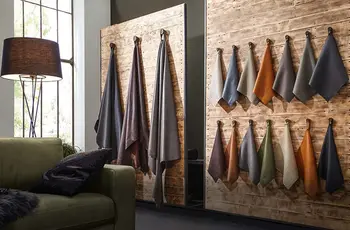 Raum mit aufgestellten Holzwänden, an denen Muster von unterschiedlichen Ledern hängen.