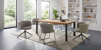 Esstisch mit gepolsterten Stühlen in hellem Esszimmer.