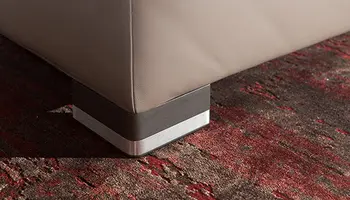 Eckfuß eines Bettes auf rotem Teppich