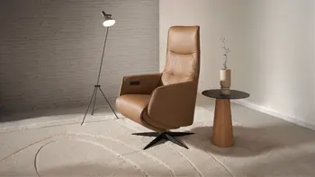 Eleganter camel farbener Relaxsessel in Leder mit schwarzem Sternfuß.