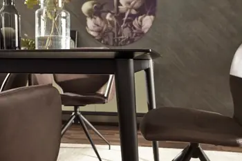 Ecke eines Esstisches mit schwarzem Gestell.