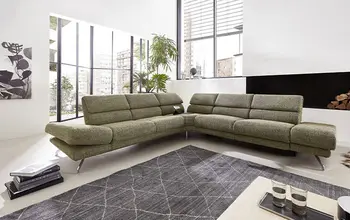 Großes grünes Ecksofa mit klappbaren Kopfstützen.