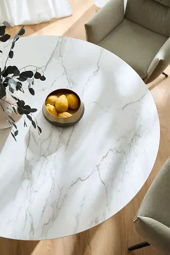 Runde Tischplatte aus Keramik in Marmoroptik in stilvoll eingerichtetem Esszimmer.