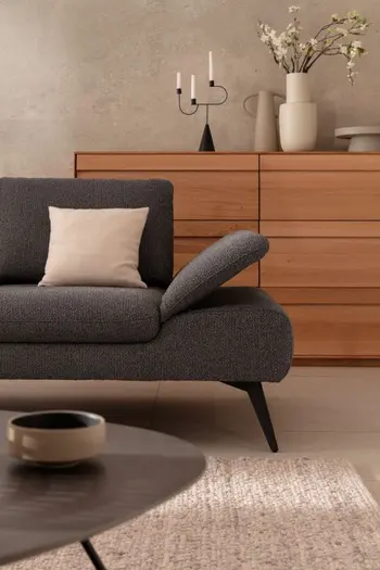 Zeitloses graues Designersofa mit rechts hochgeklappter Armlehne.