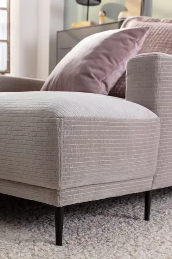 Eine Detailansicht einer Ottomane eines Stoffsofas