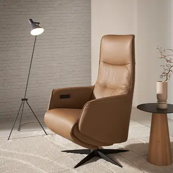 Camel farbener Design Relaxsessel neben einem runden Beistelltisch mit schwarzer Tischplatte.