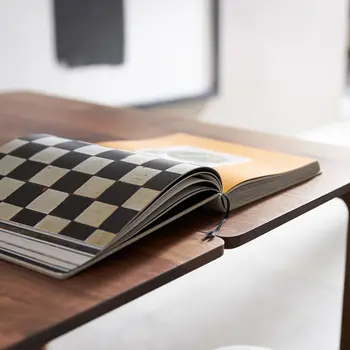 Massivholz Esstisch auf dem ein aufgeschlagenes Buch liegt.