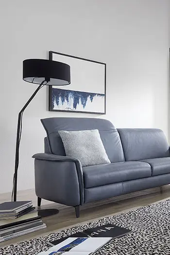 Blaues Ledersofa mit aufgestellter Kopfstütze.