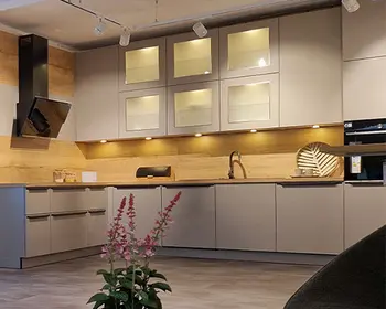 Weiße L-Küchenzeile mit Holzarbeitsplatte und Lichtspots für ein hellen Arbeitsplatz.&nbsp;