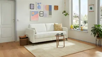 Weißes Zweisitzer Sofa in einem hellen Raum. 