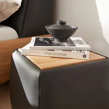 Nachttisch bezogen mit schwarzem Leder und Ablagefläche aus Holz, dekoriert mit Büchern.