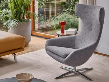 Grauer stylisher Drehsessel mit großer Kopfstütze und Fuß aus Edelstahl von Leolux.&nbsp;