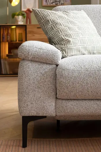 Armlehne eines grauen Ecksofas.