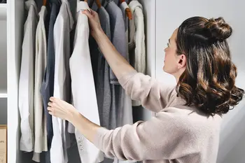 Frau verstaut Kleidung im Srank im Hauswirtschaftsraum