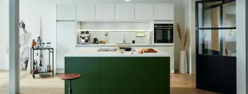 Designer Küche mit grüner Kücheninsel und weißen Schränken.
