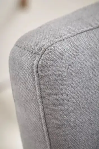 Rückenlehne eines grauen Stuhls.