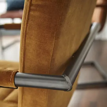 Gestell eines Freischwingers mit verschweisten Ecken in grauem Metall mit Rückenlehne in Leder in Senfgelb.