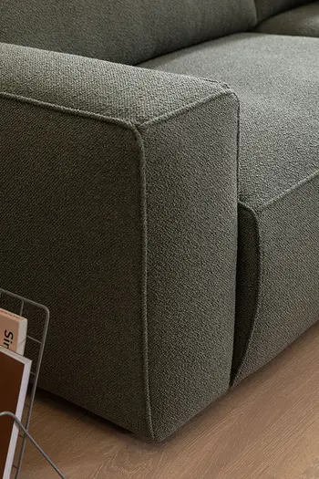 Geradlinige Armlehne eines Sofas mit grünem Soffbezug.