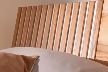 Kopfteil eines Bettes mit Lamellen in Holz mit weißen Akzenten.