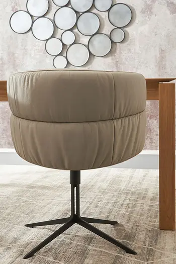 Runde Rückenlehne eines Esszimmerstuhls mit beigem Lederbezug und schwarzem Stativgestell.