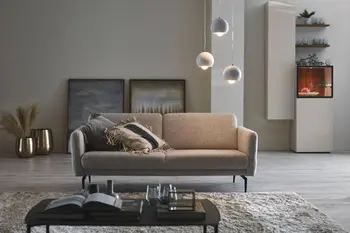 Elegantes graues Sofa mit schwarzen Füßen.