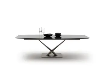 Designer Esstisch mit schwarzer Keramik Tischplatte in Marmor Optik und schwarzem Fußgestell mit schwarzem Geschirr und Kerzenständer auf der Tischplatte.