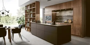 Hoelzerne Inselkueche mit dunkelbraunen Lackakzenten und freistehendem Regalelement.