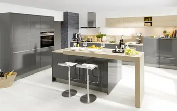 Kücheninsel mit eingebautem Tresse und zwei Hockern, im Hintergrund eine passende Küchenzeile mit gleichen grauen Fronten.&nbsp;