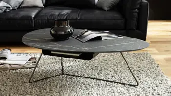 Designer Bestelltisch mit ovaler Tischplatte in schwarzem Keramiklook und schwarzem Metallgestell.