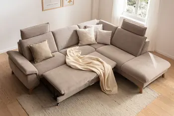 Beiges Ecksofa mit zwei Kopfstützen, bei dem die Sitzfläche nach vorne ausgezogen ist.