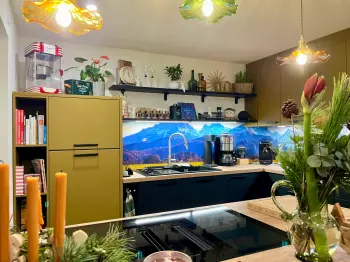 Gesamtansicht einer farbenfrohen Küche mit olivgrünen Oberschränken