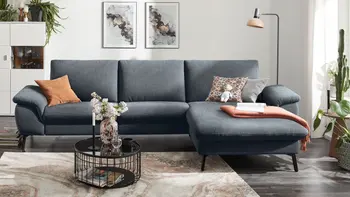 Modernes Ecksofa Global Wohnen Gotera mit grauem Stoffbezug in gemütlichem Wohnzimmer.