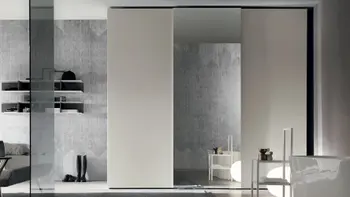 Moderner zeitloser Schiebetürenschrank mit beigen Türen und Spiegel in der Mitte.