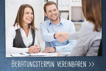 Ein lächelndes Paar bei einem Beratungsgespräch, der Mann gibt einer Beraterin die Hand.