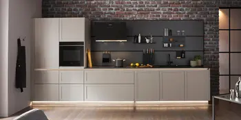 Moderne Küchenzeile in Grau mit dunkler Nischenwand und Backofen.