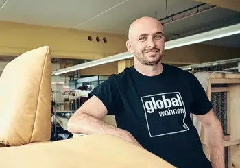 Mann mit Global Wohnen T-shirt steht in einer Produktionsstätte.