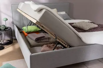 Ein graues Polsterbett mit geöffneten Bettkasten
