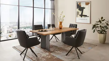 Modernes Esszimmer mit großem Esstisch und schwarzen Armlehnstühlen in schwarzem Leder.