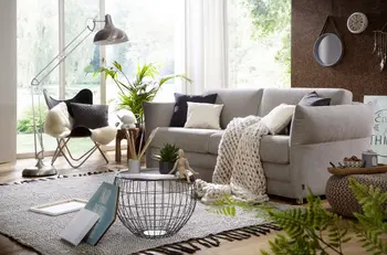 Sie sehen ein Schlafsofa in Hellgrau mit Deko