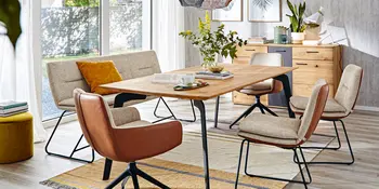 Hoelzerner Tisch mit Polsterbank und gepolsterten Stuehlen. 