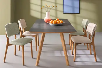 Esszimmerstühle mit Massivholz Gestell und Stoffbezug in grün und Natur um einen Esstisch mit schwarzer Tischplatte.