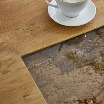 Couchtisch mit Glasfenster in dem Holz zu sehen ist.