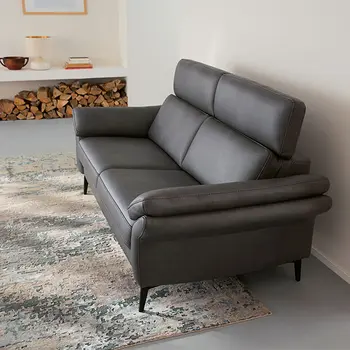 Graue Design Leder Garnitur vor einer weißen Wand.