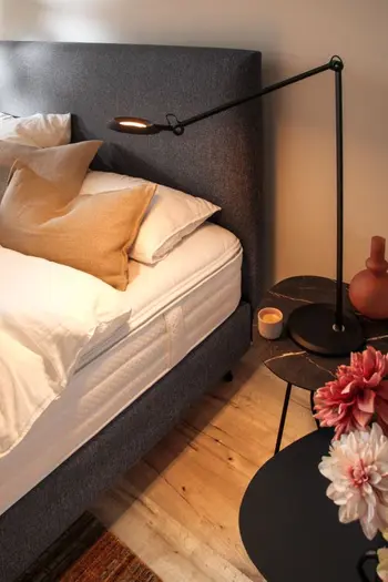 Designer Beistelltische in schwarz und marmoroptik neben bett.